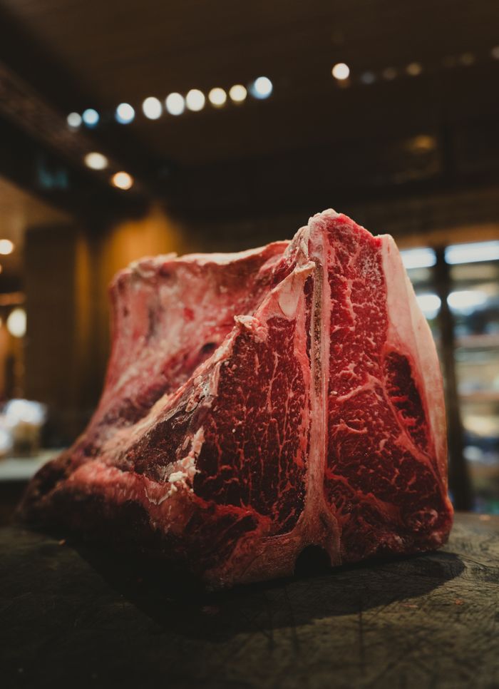 Crafting Captivating Headlines: Your awesome post title goes here Close-up of a raw marbled beef cut on a wooden surface in a warm kitchen setting.